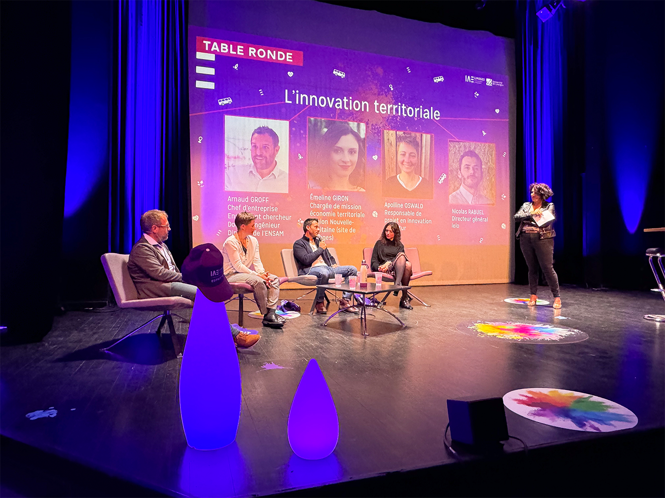 Des personnes sont installées sur scène autour d'une table et discutent dans le cadre de la table ronde organisée pour le lancement de la 7e édition des Ateliers de l'Innovation.